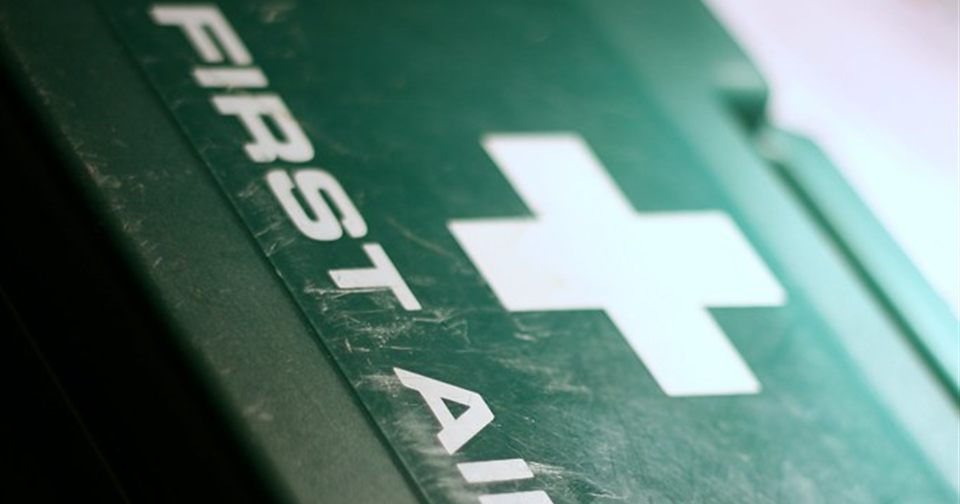 A green workplace first aid box marked with the white first aid cross