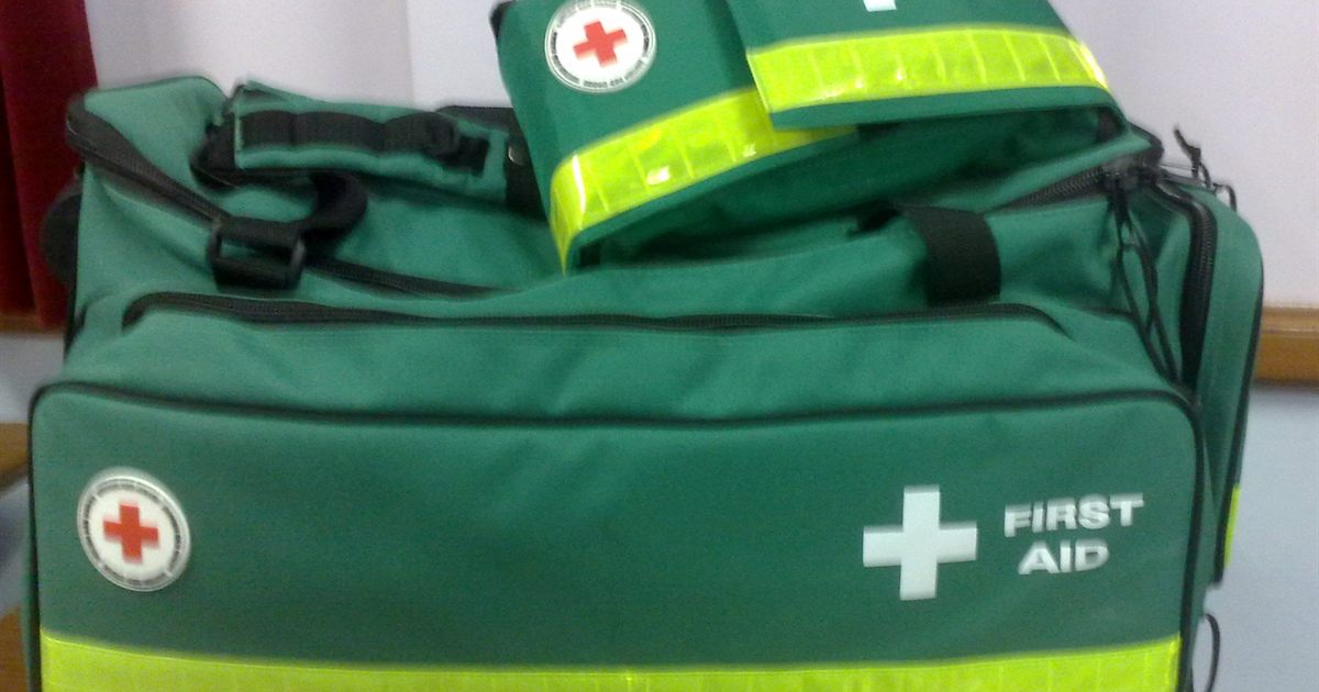 Green UK workplace first aid kits with hi-vis strips lined up ready for a needs assessment